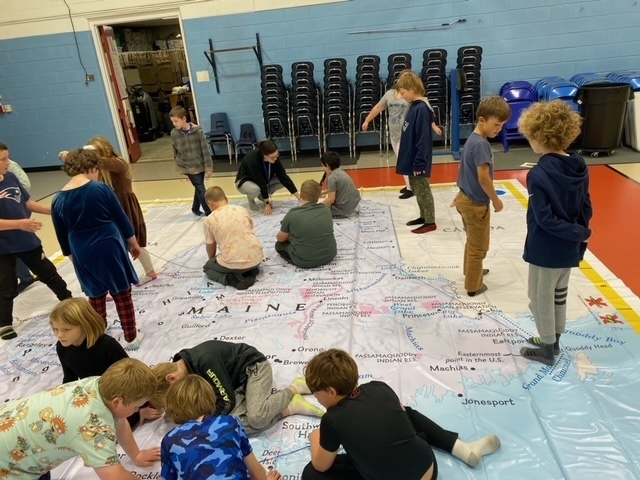 Gr 4 students standing on giant map