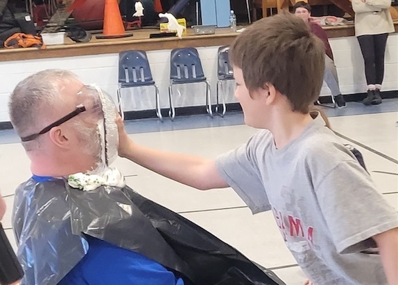 child putting a pie in adult's face