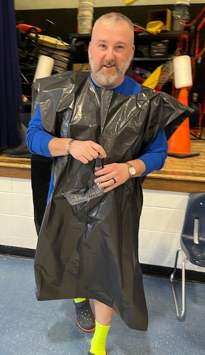 adult wearing plastic covering and carrying goggles