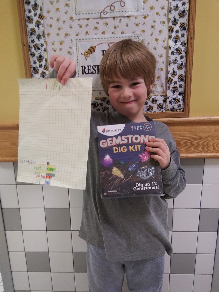 blond boy holding up weather graph and gemstone dig kit prize