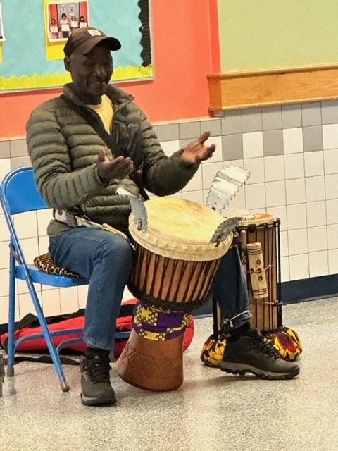 man demonstrating african drum playing