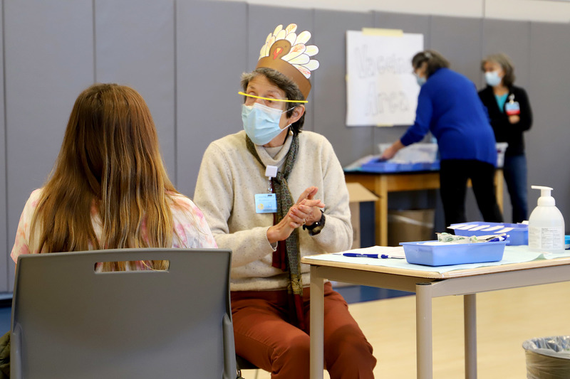 Clinician Katie Huntington prepares to administer a COVID-19 vaccine